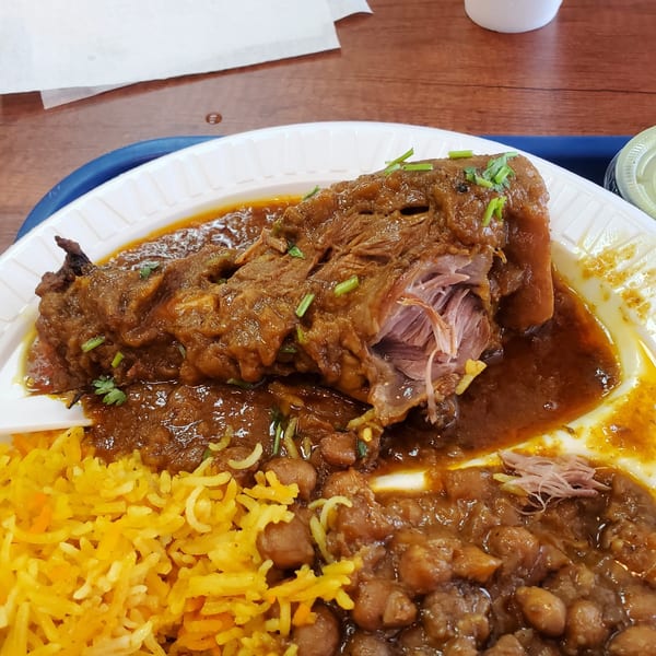 Z Kabob's lamb shank with yellow rice and chickpeas in a rich brown sauce.