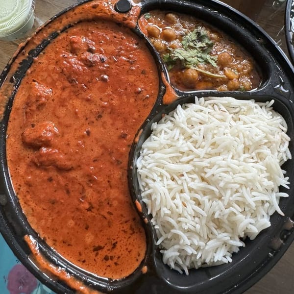 Z Kabob's chicken tikka masala, chana masala, and basmati rice in a black takeout container.